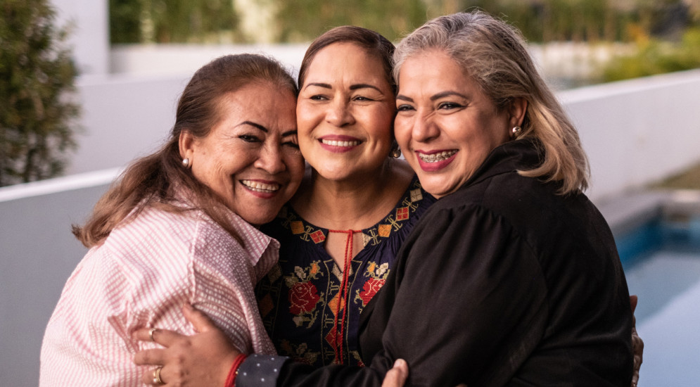Female Latin friends hugging and laughing